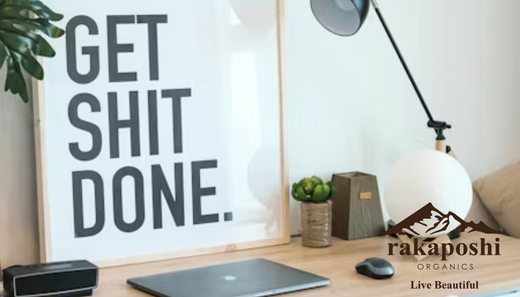 Desk workspace with motivational "get shit done" sign representing productivity, action-taking, and overcoming procrastination