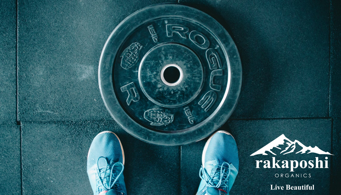 First-person view of feet beside weight plate representing strength training and body composition improvement through exercise