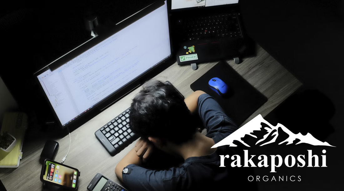 Person working on laptop appearing fatigued during afternoon work session